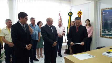 Vitor Faccin transmitindo o comando de Ouro ao prefeito eleito, Neri Miqueloto, acompanhado pelo seu vice, José Camilo Pastori
